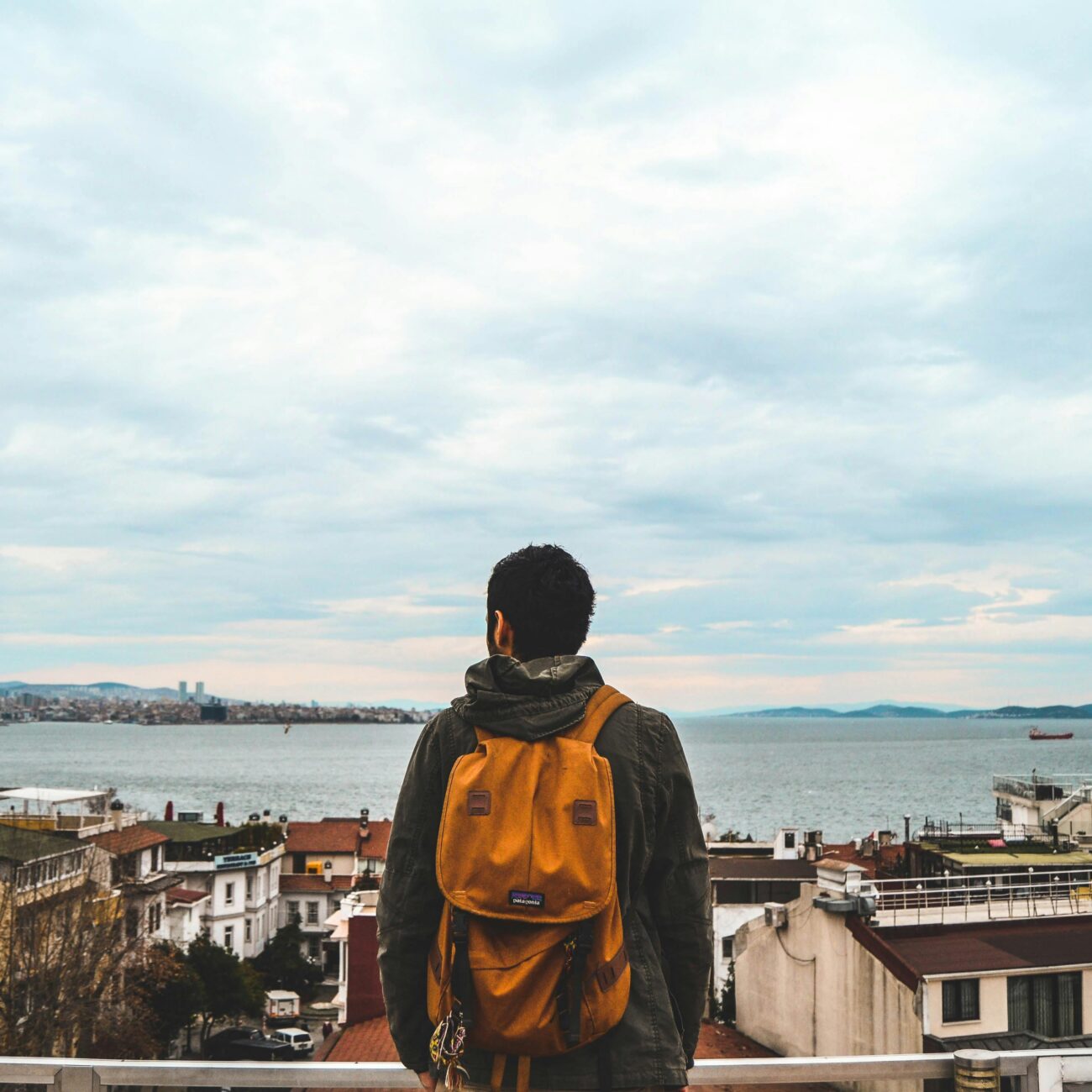 Man with a backpack overlooks the stunning seaside skyline of Istanbul, Turkey.